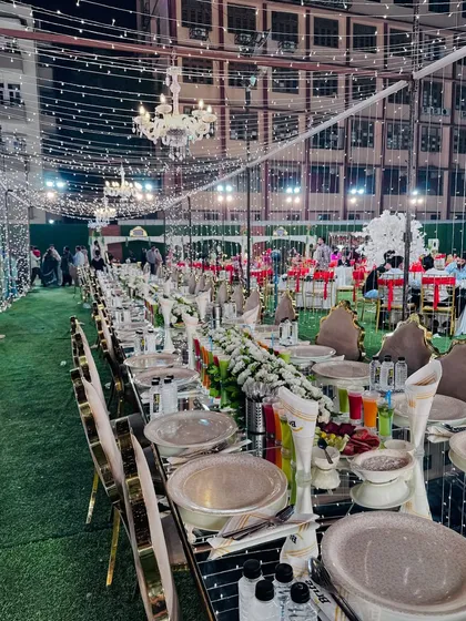 A long, mirrored dining table reflects the beautiful fairy lights and chandeliers, creating a magical dining atmosphere.
