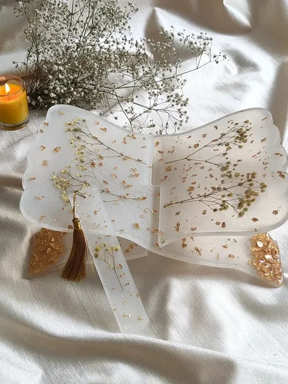 This is a handmade resin holy book stand, or rihal, created with delicate preserved baby's breath flowers and gold details. It’s designed to be a beautiful and functional piece for your sacred space.