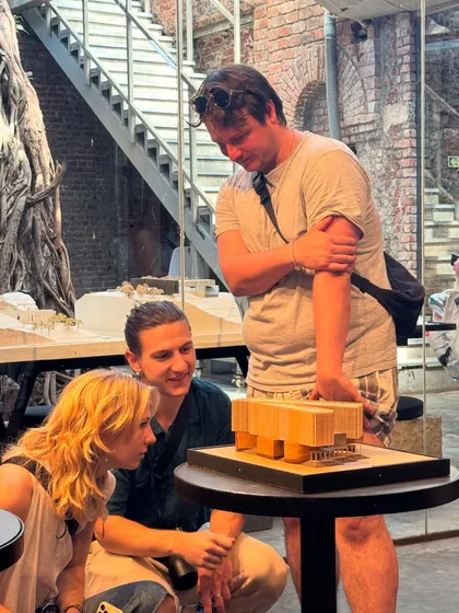 Students from Vienna examining a physical model at our IF.BE exhibition. The space is designed to encourage this kind of close study and unconventional engagement, unlike a typical "white cube" gallery.