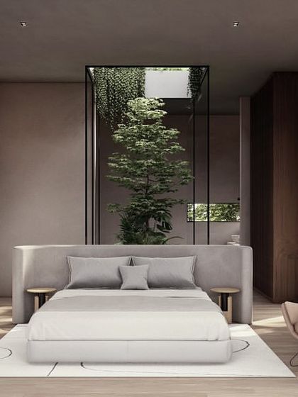 This bedroom in Moira Homes features a central courtyard behind the bed, bringing in filtered light and a private view of nature. The design uses a palette of soft, earthy tones to enhance the feeling of warm serenity.