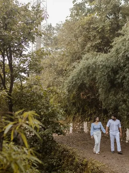 A candid shot of the couple walking through the lush greenery of the Himalayan foothills. Our destination engagement sessions are all about exploring and capturing your adventure together.