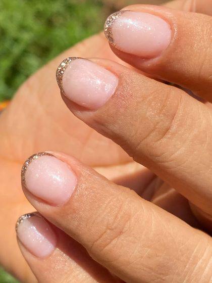 A simple yet glamorous look for short nails. This is a sheer nude overlay with a delicate gold glitter French tip.