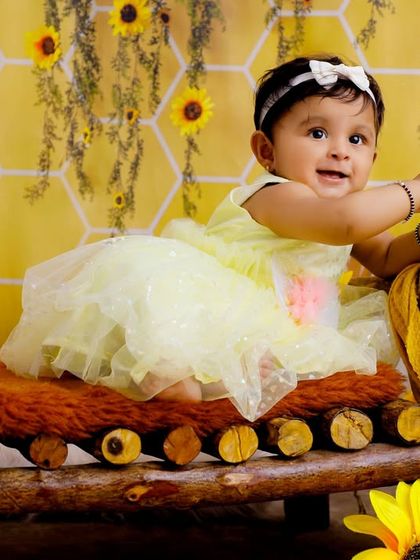 A full view of our charming honeycomb and sunflower theme, with a baby girl sitting happily on a miniature wooden bed.