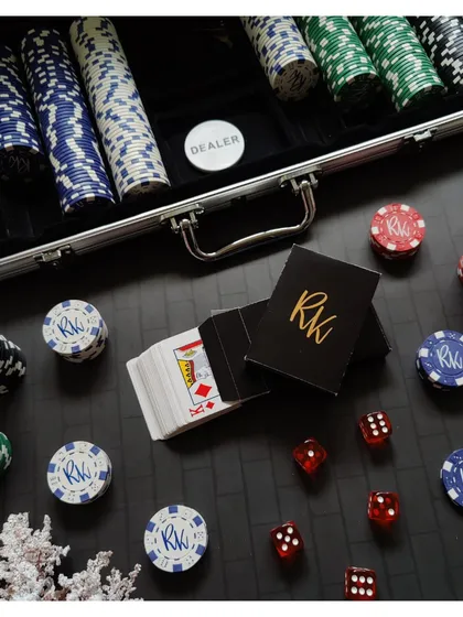 A detailed shot of the personalized "RK" poker chips and card boxes, perfect for a high-stakes game night.