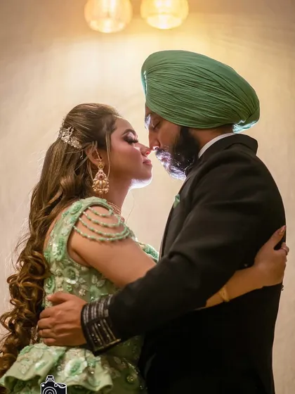 A romantic silhouette of the couple. The bride's makeup, especially the highlight and contour, looks stunning even in dramatic lighting.