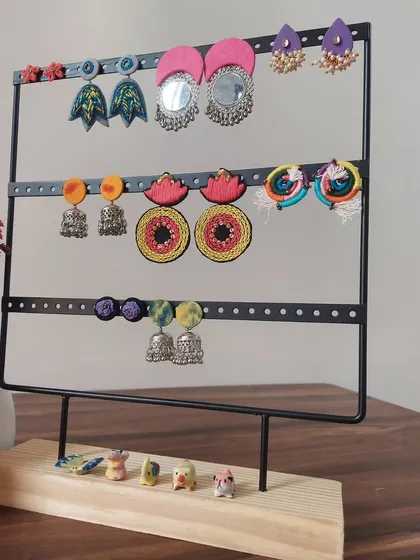 A display of the variety of earrings I create. You can see everything from large mirror work chandbalis and colorful jhumkis to hand-painted studs, all handmade by me.