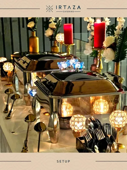 A clean and elegant buffet line using silver chafing dishes. The setup is brightened by red candles and white floral arrangements, offering a different aesthetic from my more common gold and copper serveware.