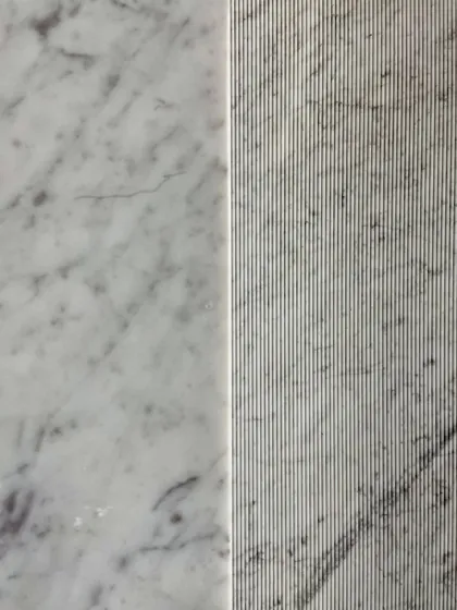 The contrast between the smooth and fluted surfaces of Carrara marble in the master bathroom. This subtle variation in texture adds a layer of refinement and sophistication to the space.