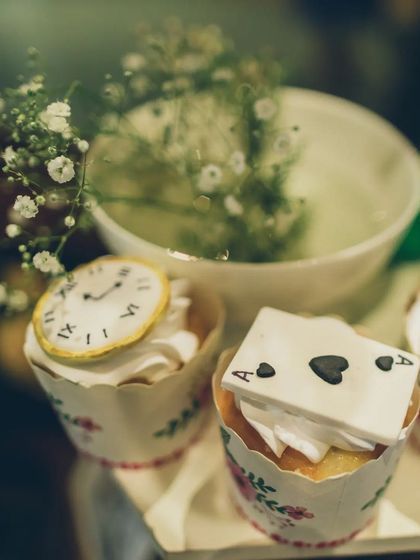 Themed desserts are a must. These cupcakes are topped with intricate, edible fondant decorations, including a tiny clock and an ace of spades playing card, perfectly fitting the Wonderland theme.