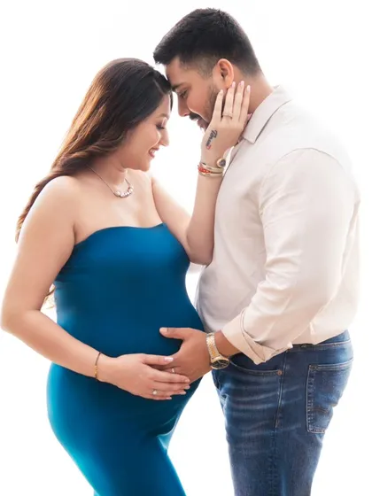An intimate close-up that captures the loving gaze between the couple. Her hand on his cheek, their foreheads touching, this portrait is all about the deep bond they share as they await their baby.