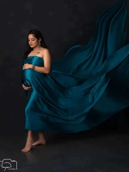 A walking pose with the fabric flowing behind her gives this portrait a sense of grace and movement, celebrating the journey of motherhood.