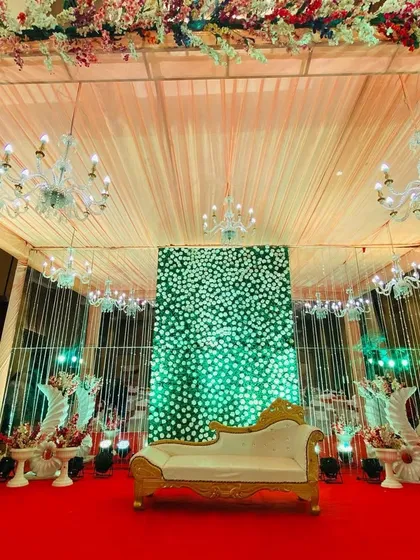 A centered shot of the indoor stage with the green floral wall, showing the beautiful ceiling and lighting of the venue.