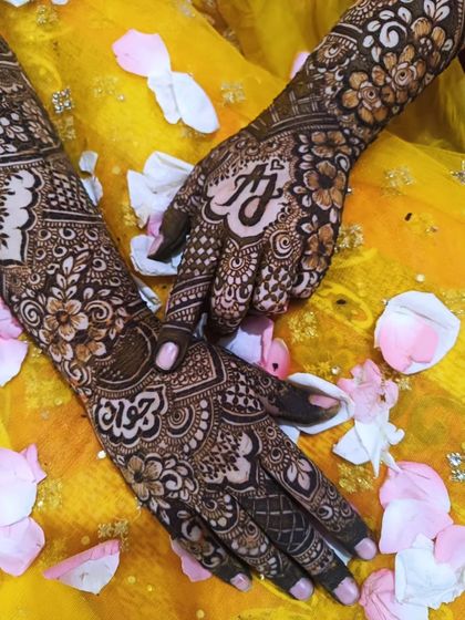 A beautifully styled shot of bride Aqsa's hands, showing the custom initials 'A' and 'J' on her palms.