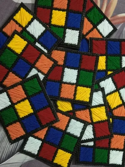 A pile of our handmade Rubik's Cube coasters. This retro design is a fun conversation starter and a great gift for anyone who loves puzzles and 80s nostalgia.
