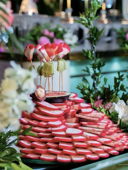 A beautiful display of fresh fruit skewers, artfully arranged amidst flowers. This is a healthy, refreshing, and visually stunning addition to any buffet or grazing table.