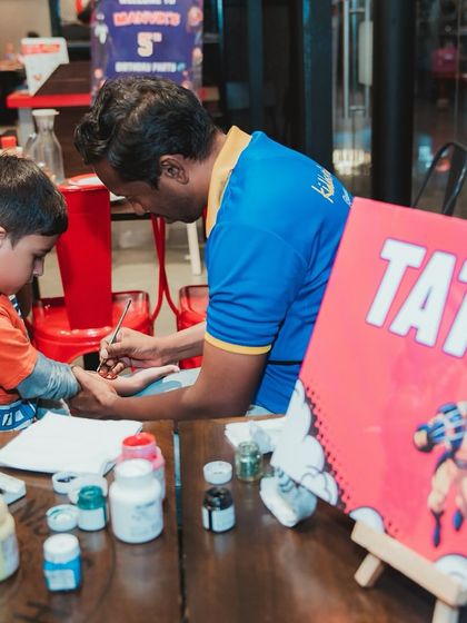 A superhero-in-training gets a temporary tattoo at Manvik's Avengers party. This station is always busy with kids excited to sport their favorite characters.