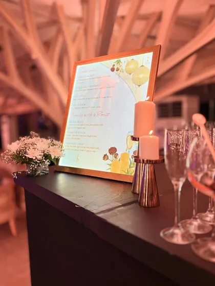 A candlelit bar scene showing our custom menu and glassware. The warm, soft lighting creates an intimate and luxurious atmosphere, perfect for an evening celebration.