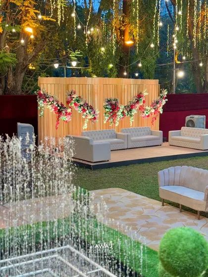 A lounge area with modern grey sofas set on the lawn, offering a relaxed space for guests to mingle.