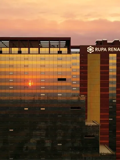 The Rupa Renaissance IT park in Navi Mumbai is captured here at sunset, with its distinctive facade reflecting the sky. This project exemplifies our focus on sustainable design, utilizing solar energy and optimal building orientation to create an energy-efficient commercial space.