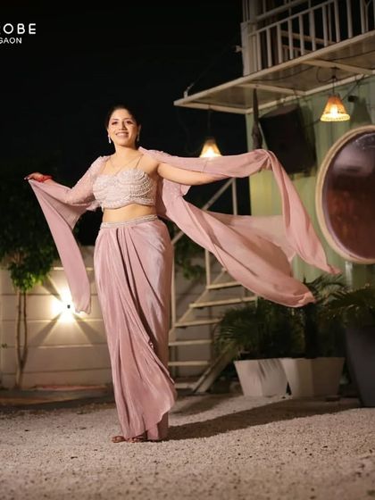 This client looks absolutely graceful in a draped, Indo-western style gown. The unique silhouette and soft color make it a sophisticated choice.