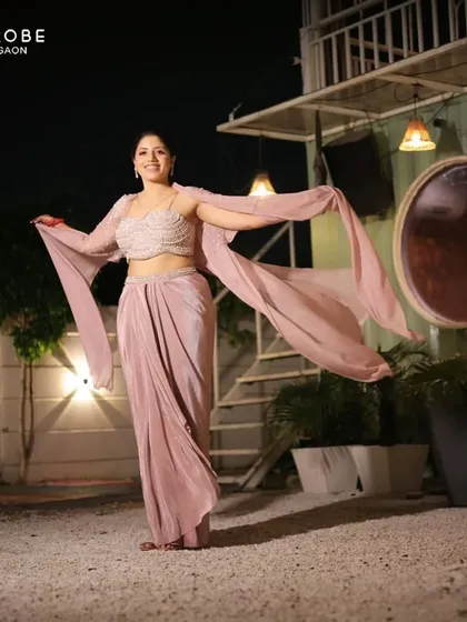 This client looks absolutely graceful in a draped, Indo-western style gown. The unique silhouette and soft color make it a sophisticated choice.