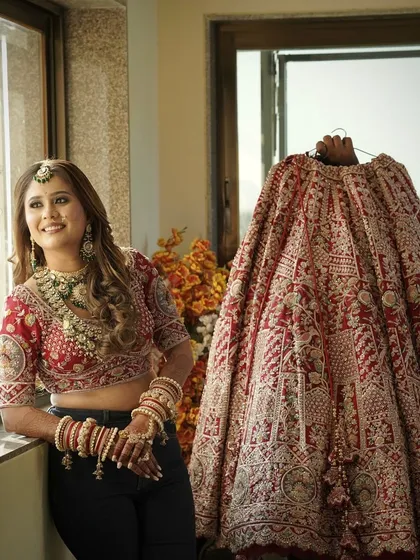 Getting ready for the big moment. A candid shot showing the bridal makeup and hair, with the magnificent lehenga waiting to be worn.