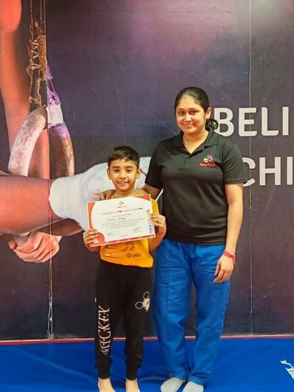 This student proudly holds his certificate, a reward for his dedication in the gym.