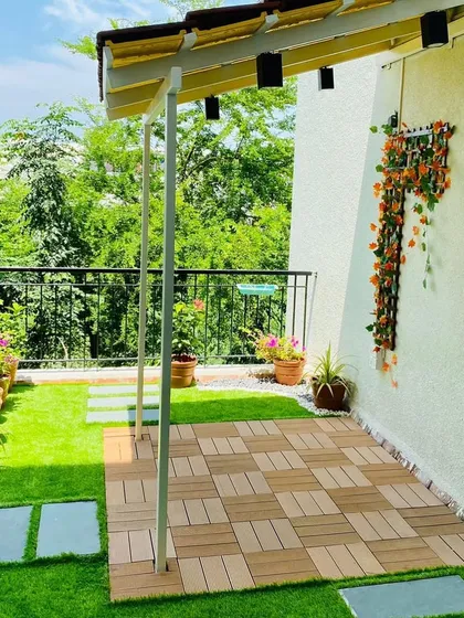 Another view of the bright balcony garden, showing how the potted plants along the railing add color and life. The space is designed to be a safe and enjoyable play area for a small child.