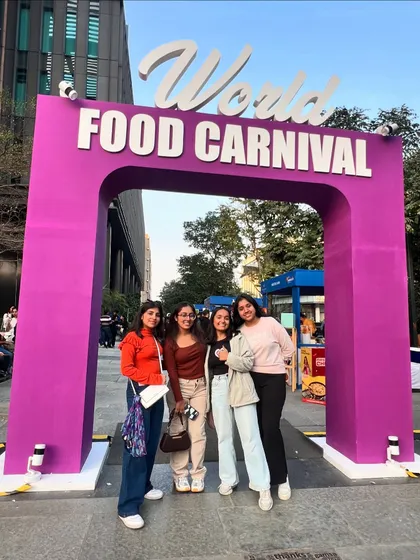 Friends gather at the entrance of the World Food Carnival. The grand entrance sets the stage for the global culinary adventure that awaits inside.