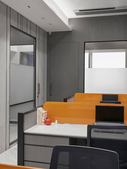 This open-plan office uses bright orange desk dividers to add a splash of energy. The layout is designed for collaboration, with ample storage and clean lines to ensure a clutter-free and productive environment.