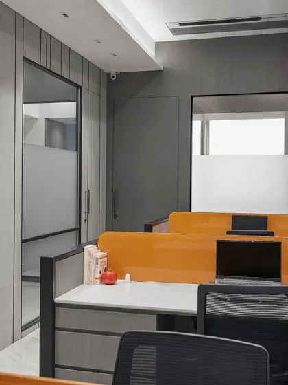 This open-plan office uses bright orange desk dividers to add a splash of energy. The layout is designed for collaboration, with ample storage and clean lines to ensure a clutter-free and productive environment.