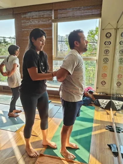 Here, I am assisting a student with a partner exercise to improve shoulder flexibility. Gentle, guided adjustments are key to practicing safely and effectively.