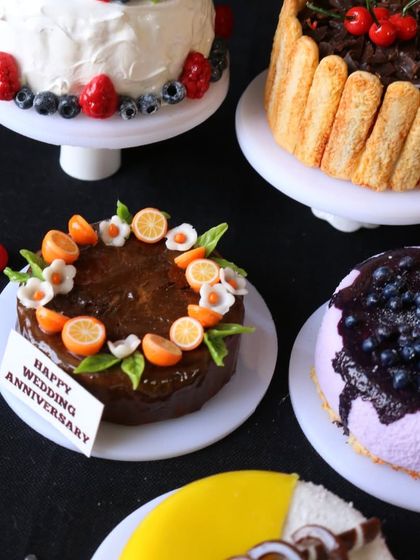 A close-up of a miniature chocolate fruit cake and a blueberry cheesecake.