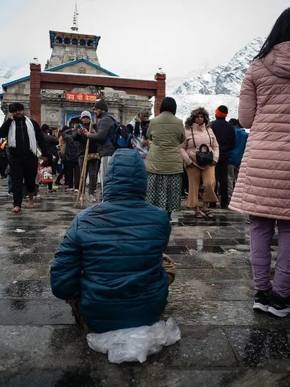 Amidst thousands of devotees, one can still find a moment of solitary connection. This pilgrim sits in quiet contemplation before the Kedarnath temple, a moment of personal peace within a sea of collective energy. The mountains help you find yourself even when you are surrounded by many.
