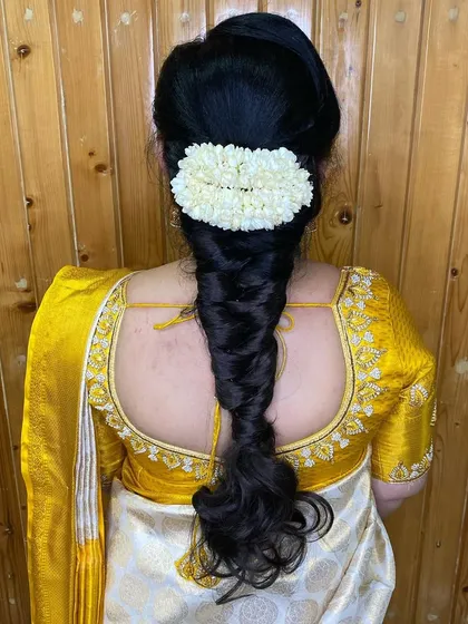 A beautiful fishtail braid adorned with a simple jasmine gajra. This is a classic and elegant hairstyle that is perfect for any wedding event.