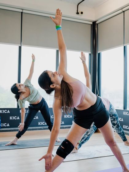 A student gracefully moving into Triangle Pose (Trikonasana) during our International Yoga Day event. This pose is wonderful for creating space and length in the body.