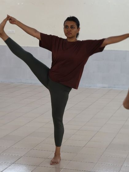 A student demonstrates Utthita Hasta Padangusthasana, a standing balance pose that improves focus and leg flexibility.