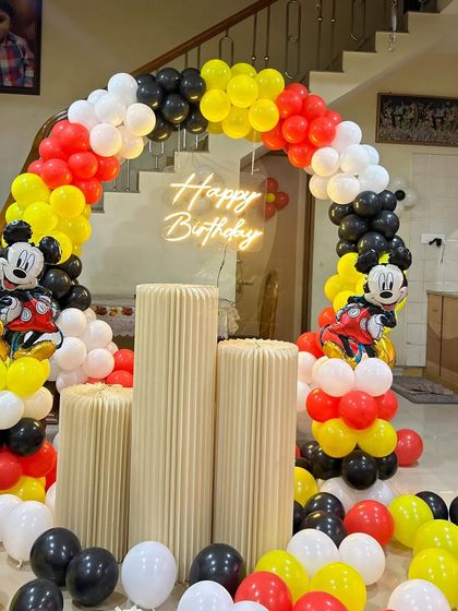 A classic Mickey Mouse theme with a balloon arch in red, yellow, black, and white, complete with Mickey Mouse foil balloons.