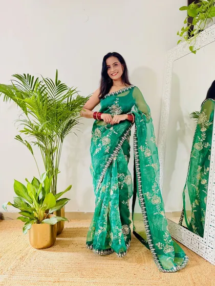 This green organza saree with silver floral embroidery is a beautiful choice for festive events. The lightweight fabric and intricate work make it look very graceful.