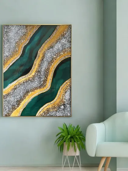 This resin wall art, named 'Glimmering Mirage', is a stunning abstract piece for a modern home. The flowing currents of emerald green are highlighted with glittering silver crystals and veins of gold foil, creating a sense of depth and luxury.