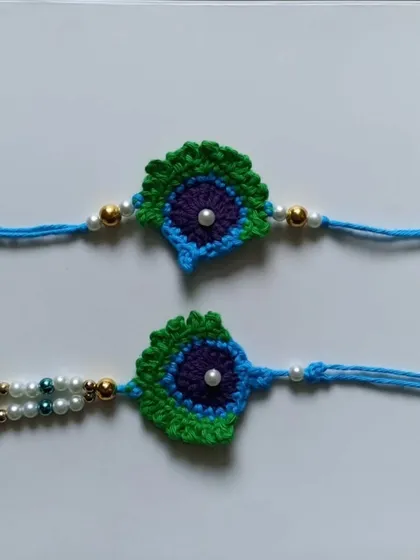 The classic peacock feather or *mor pankh* design, reimagined in crochet for Raksha Bandhan. These rakhis are detailed with pearls for an elegant touch.