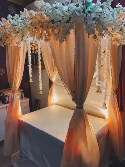 This unique canopy-style mandap creates a truly special and intimate space for Bappa, using delicate white blossoms and flowing fabric.