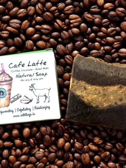 Our Café Latte Soap bar resting on a bed of coffee beans, showcasing the natural origin of its rejuvenating and exfoliating properties.