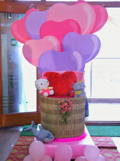 A whimsical prop featuring cartoon heart balloons and cute stuffed animals like Hello Kitty. This kind of custom piece can be a fun addition to a child's birthday party or a valentine's themed event.