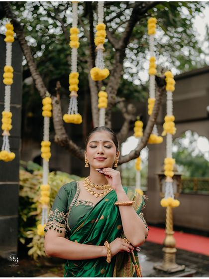 A moment of quiet contemplation, surrounded by flowers. This close-up highlights the bride's beautiful jewelry and serene expression.