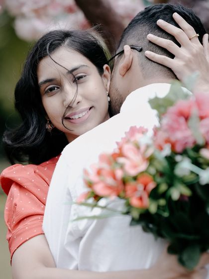 A beautiful, happy moment of a bride hugging her groom from behind, her smile radiant.