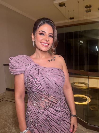 A full view of the client, showing how the modern updo complements her one-shoulder gown.