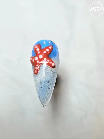 A fun, beach-themed nail featuring a 3D starfish and bubble effect. Our students learn to create various textures and themed designs.