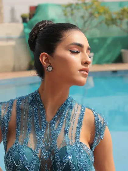 A sun-kissed shot by the pool. The blue of the gown contrasts beautifully with the water, creating a fresh and glamorous summer look.