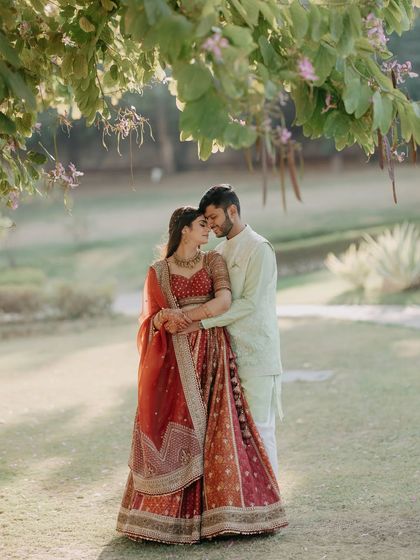 Vasudha and Harshit in a classic romantic pose amidst lush greenery. This portrait is a testament to timeless love, perfectly framed by nature, showcasing a serene and beautiful connection.